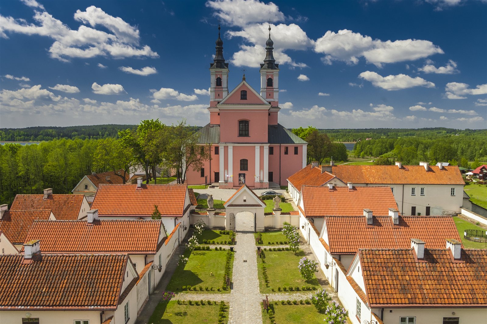 Pokamedulski klasztor w Wigrach z czerwonymi dachami i jeziorem w tle